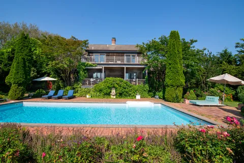 a view of a house with swimming pool and sitting area