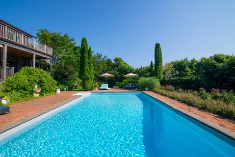 a view of a house with pool and a yard