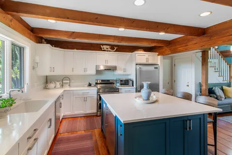 a kitchen with stainless steel appliances granite countertop a table chairs sink and cabinets