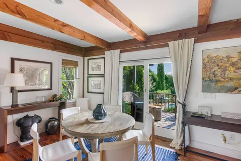 a view of a dining room with furniture a chandelier and wooden floor