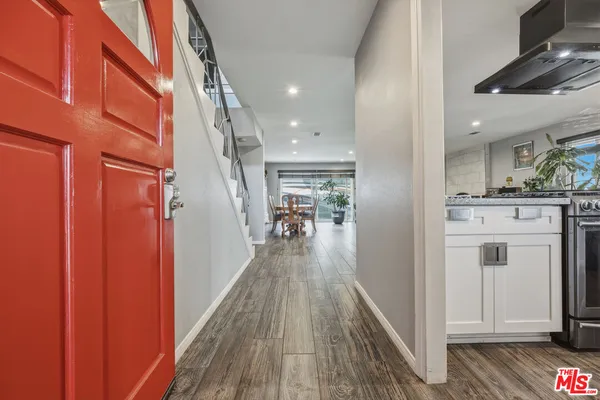 a kitchen with granite countertop a sink stainless steel appliances and white cabinets