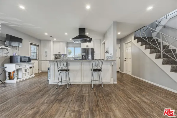 a kitchen with stainless steel appliances kitchen island granite countertop a stove and a sink