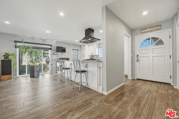 a large kitchen with stainless steel appliances granite countertop a stove top oven a sink and a refrigerator