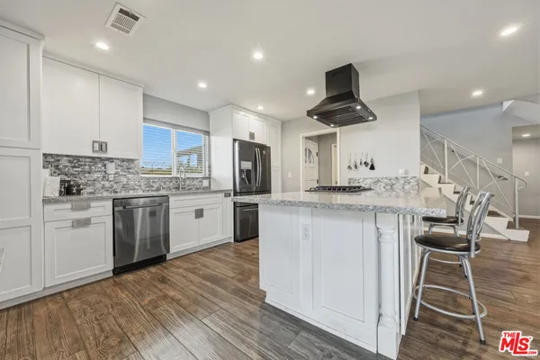 a kitchen with a stove and white cabinets