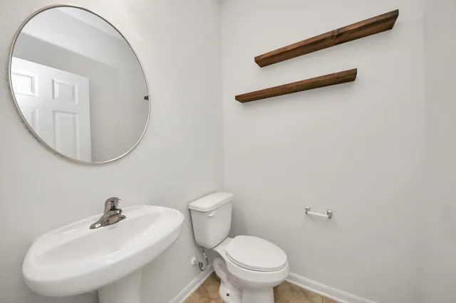 a bathroom with a sink a toilet and a mirror
