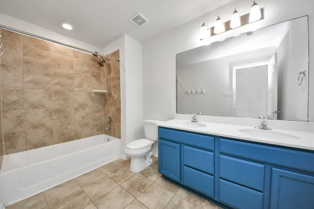 a bathroom with a double vanity sink mirror toilet and bathtub