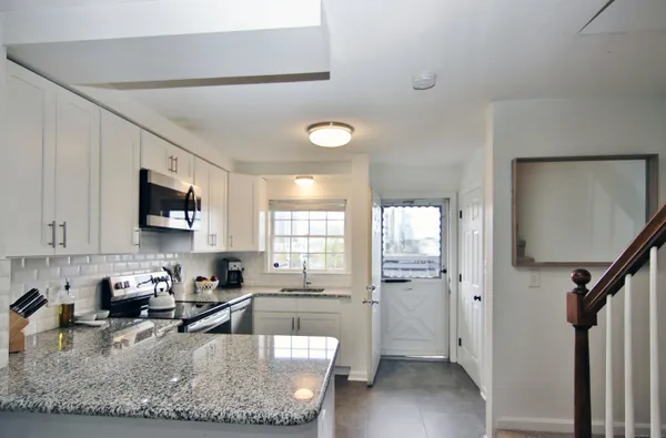 a view of a kitchen with sink a window and stainless steel appliances