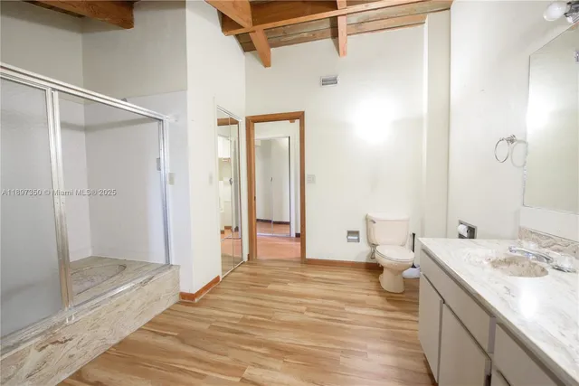 an empty room with a chandelier fan and windows