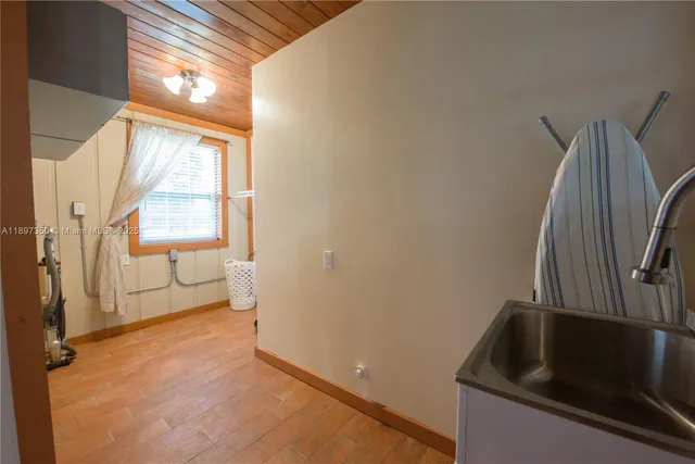 a room with white cabinets and wooden floor