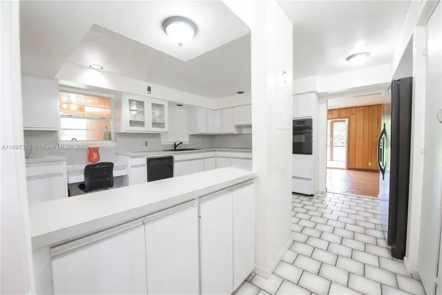 a kitchen with a sink cabinets and window