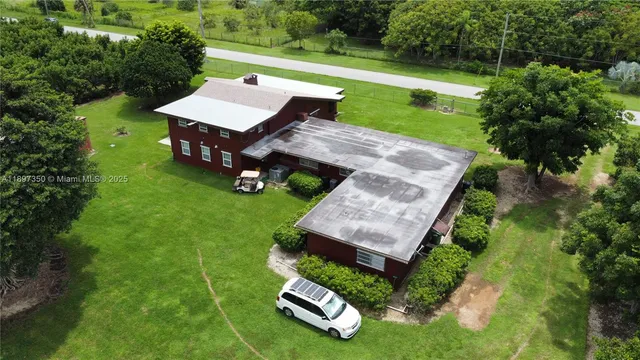 a view of a house with a lush green forest