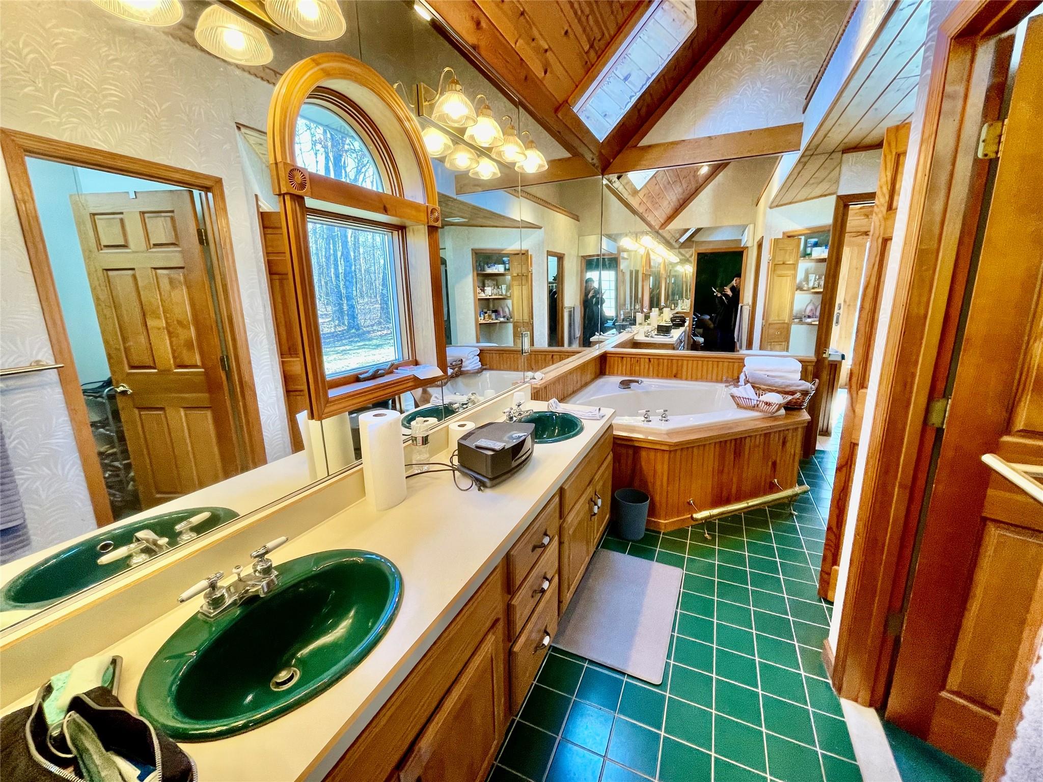 71 Saddleback Ridge Wallkill, NY 12589 - Photo 32 of 39 Full bathroom featuring lofted ceiling, tile patterned floors, wallpapered walls, a garden tub, and vanity