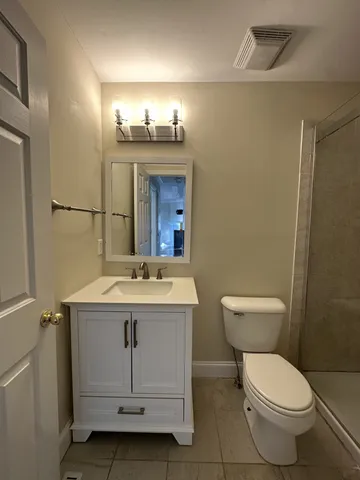 a bathroom with a toilet a sink and mirror