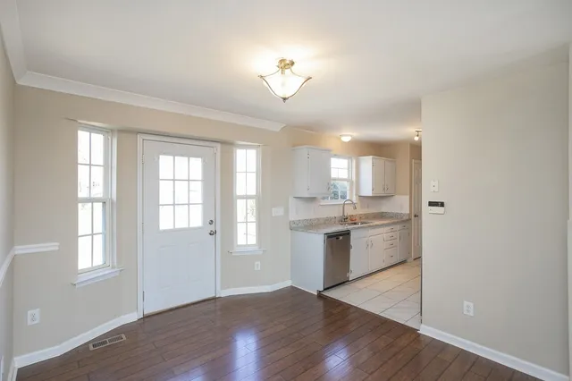 a kitchen with granite countertop a stove a sink and a refrigerator