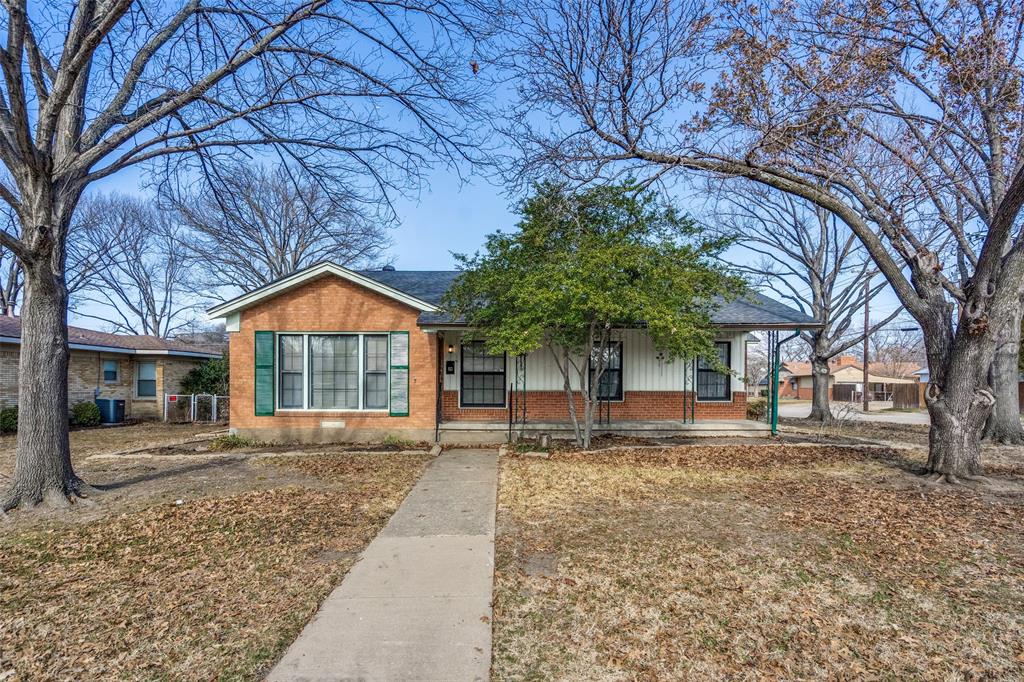 a front view of a house with a yard and trees