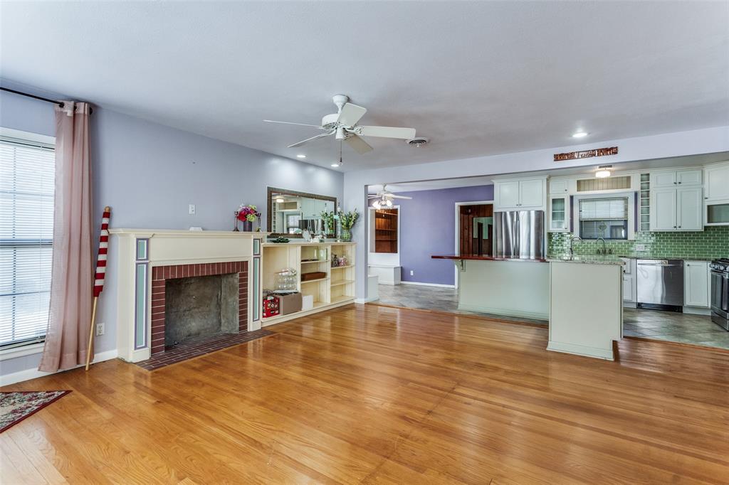 813 19th Street Plano, TX 75074 - Photo 2 of 12 a view of a kitchen with furniture a fireplace and wooden floor