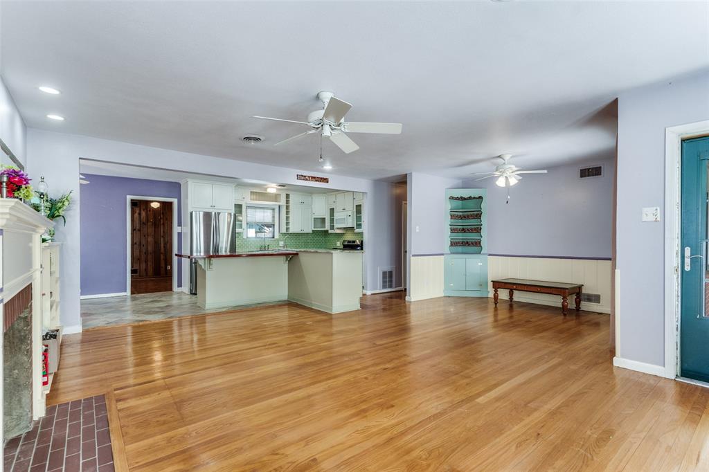 813 19th Street Plano, TX 75074 - Photo 4 of 12 a view of an empty room with wooden floor and a kitchen