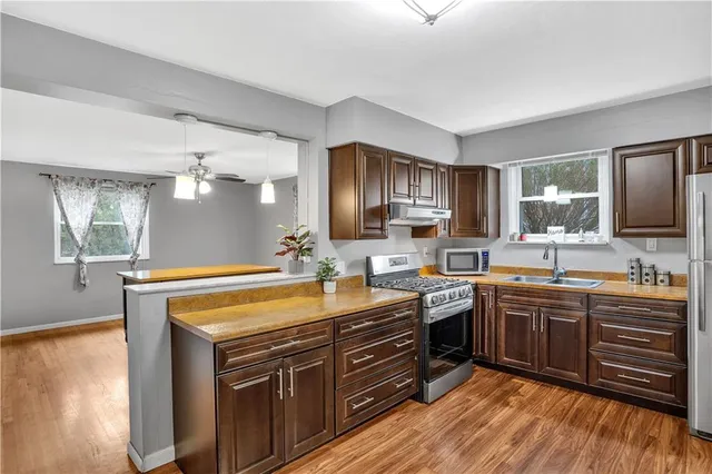 a kitchen with stainless steel appliances granite countertop a sink stove and refrigerator