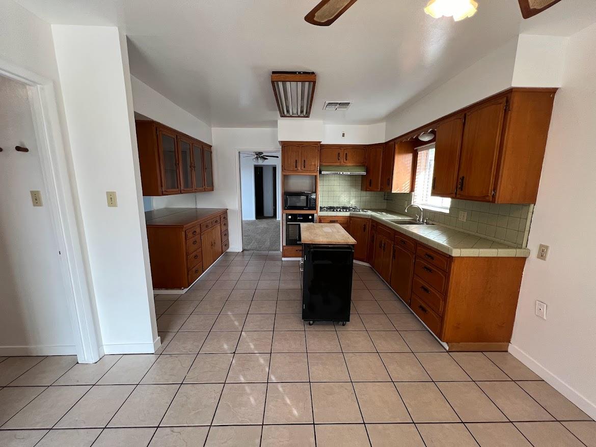 16109 East Manning Reedley, CA 93654 - Photo 7 of 30 a kitchen with stainless steel appliances granite countertop a stove a sink and a refrigerator