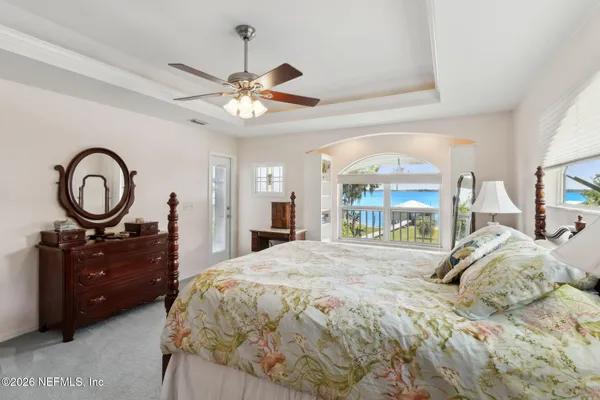a bedroom with a bed window and a chandelier