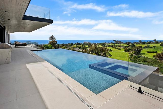 a living room with furniture large windows and floor to ceiling window