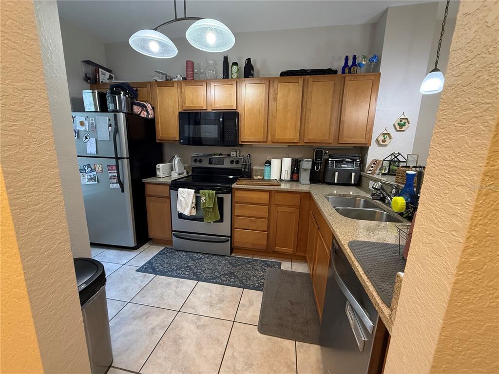 2508 Southwest 35th Place, Unit S111 Gainesville, FL 32608 - Photo 7 of 22 a kitchen with stainless steel appliances granite countertop a sink a stove top oven a counter space and cabinets
