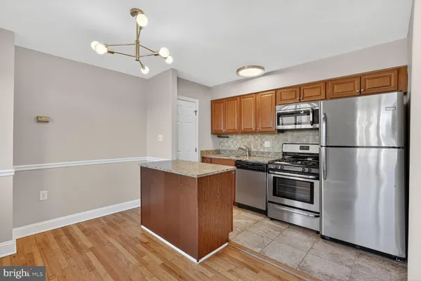 a kitchen with stainless steel appliances a refrigerator and a stove top oven