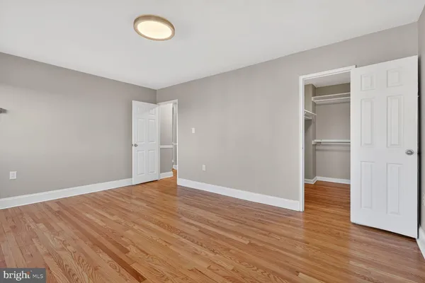 an empty room with wooden floor and closet