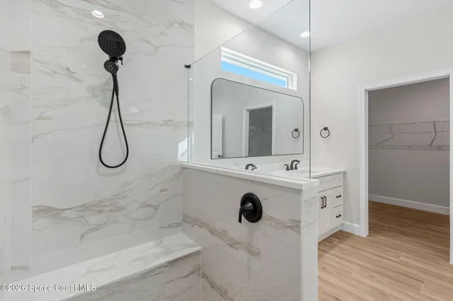 a bathroom with a tub sink shower and mirror