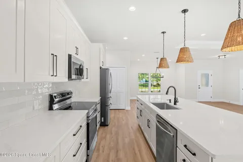 a kitchen with kitchen island a sink a stove and refrigerator