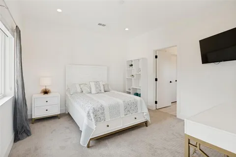 a spacious bedroom with a bed and tv