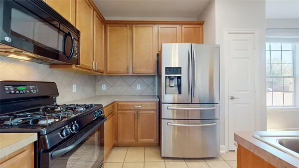 a kitchen with stainless steel appliances a refrigerator and a stove top oven