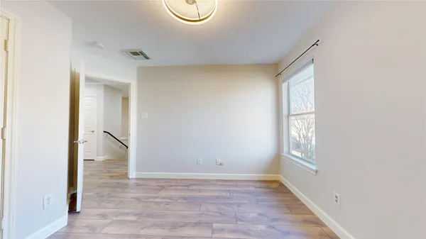 a view of room with window and wooden floor