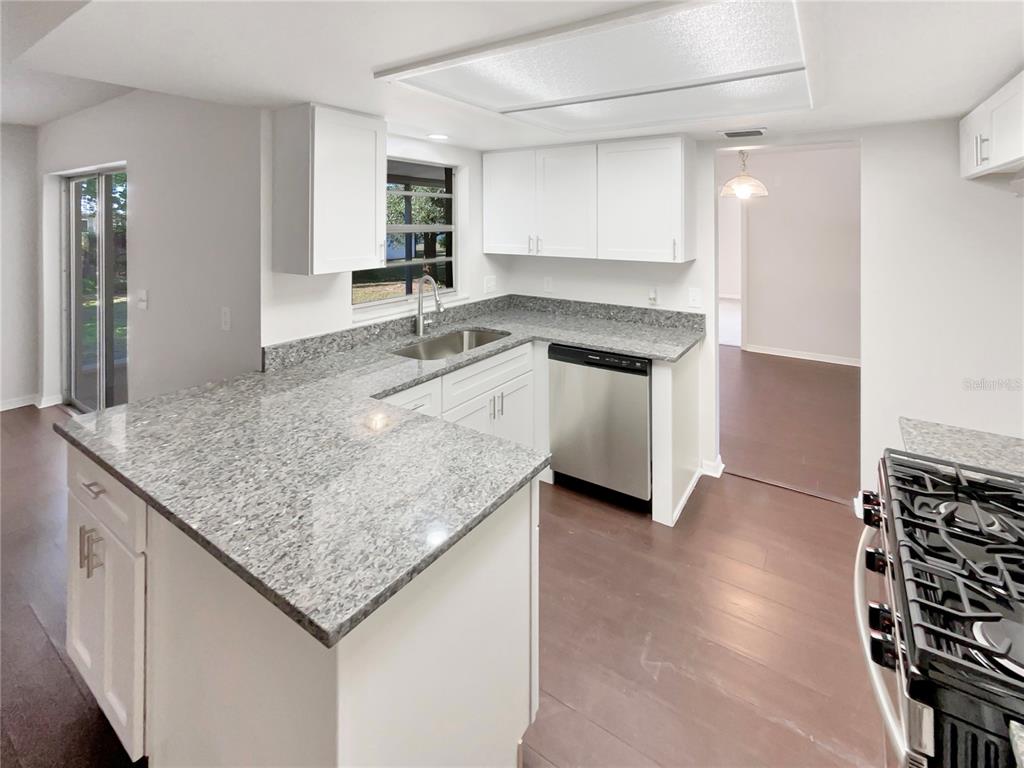 352 Sesame Avenue Apopka, FL 32703 - Photo 17 of 27 a kitchen with granite countertop a sink and a stove