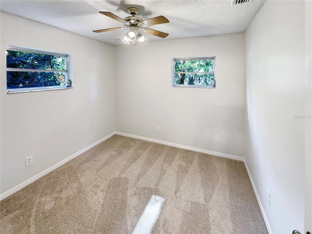 352 Sesame Avenue Apopka, FL 32703 - Photo 22 of 27 an empty room with windows and fan
