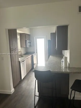 a kitchen with kitchen island a sink stove and refrigerator