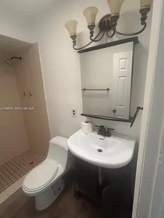 a bathroom with a sink a toilet and mirror