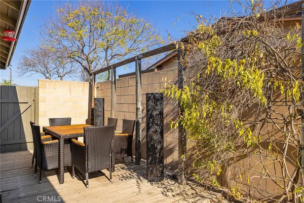 a view of a patio with table and chairs and floor to ceiling window with wooden floor