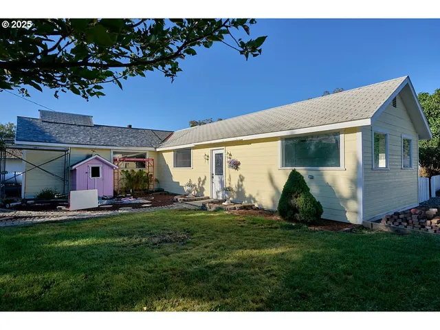 a front view of a house with a garden and plants