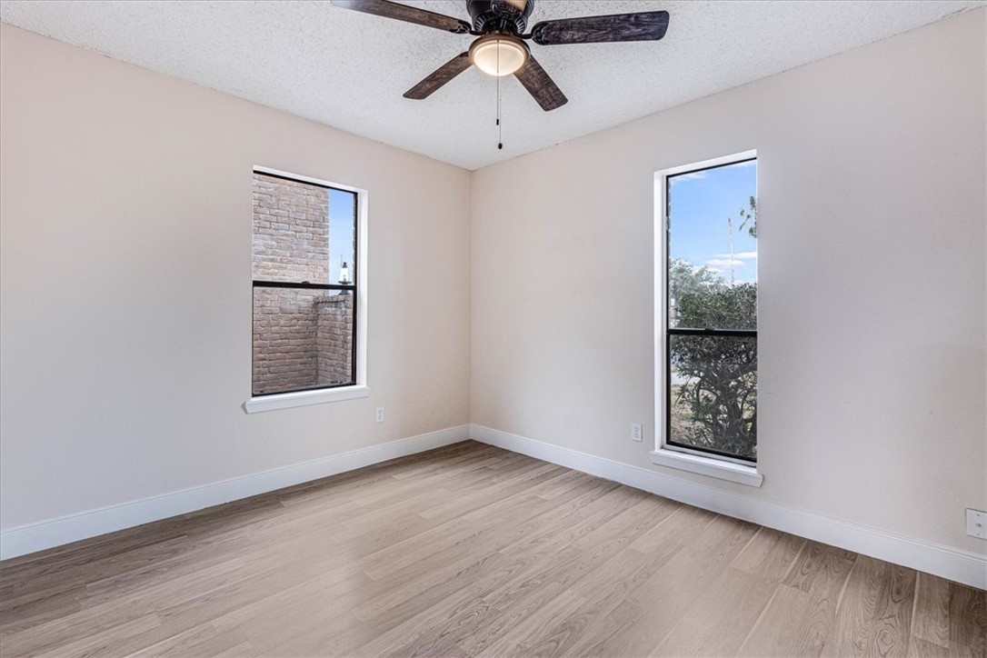 985 Crossbill Street Corpus Christi, TX 78418 - Photo 14 of 40 a view of an empty room with a window and wooden floor