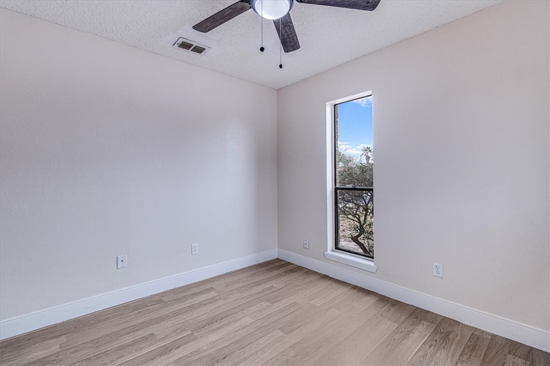 985 Crossbill Street Corpus Christi, TX 78418 - Photo 23 of 40 a view of an empty room with window and wooden floor