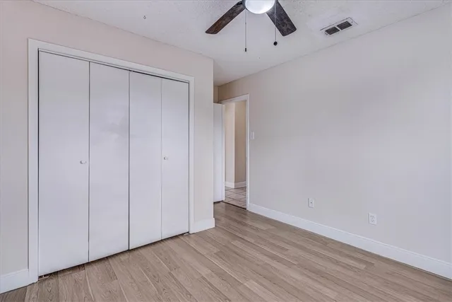 a view of an empty room with wooden floor