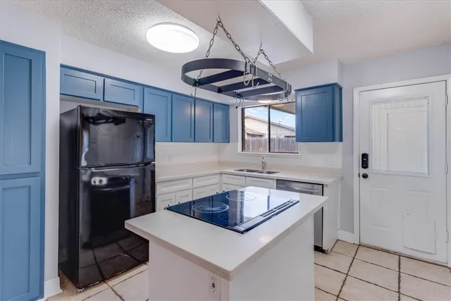 a kitchen with stainless steel appliances a sink a refrigerator a stove a microwave and cabinets