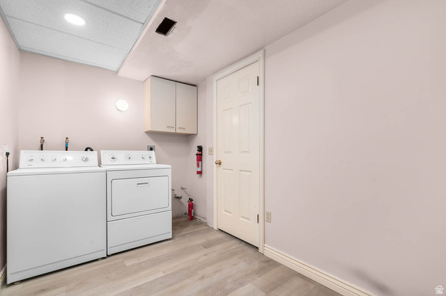 1822 East 9800th Street South Sandy, UT 84092 - Photo 34 of 38 Laundry room featuring light wood-style floors, washer and clothes dryer, and cabinet space
