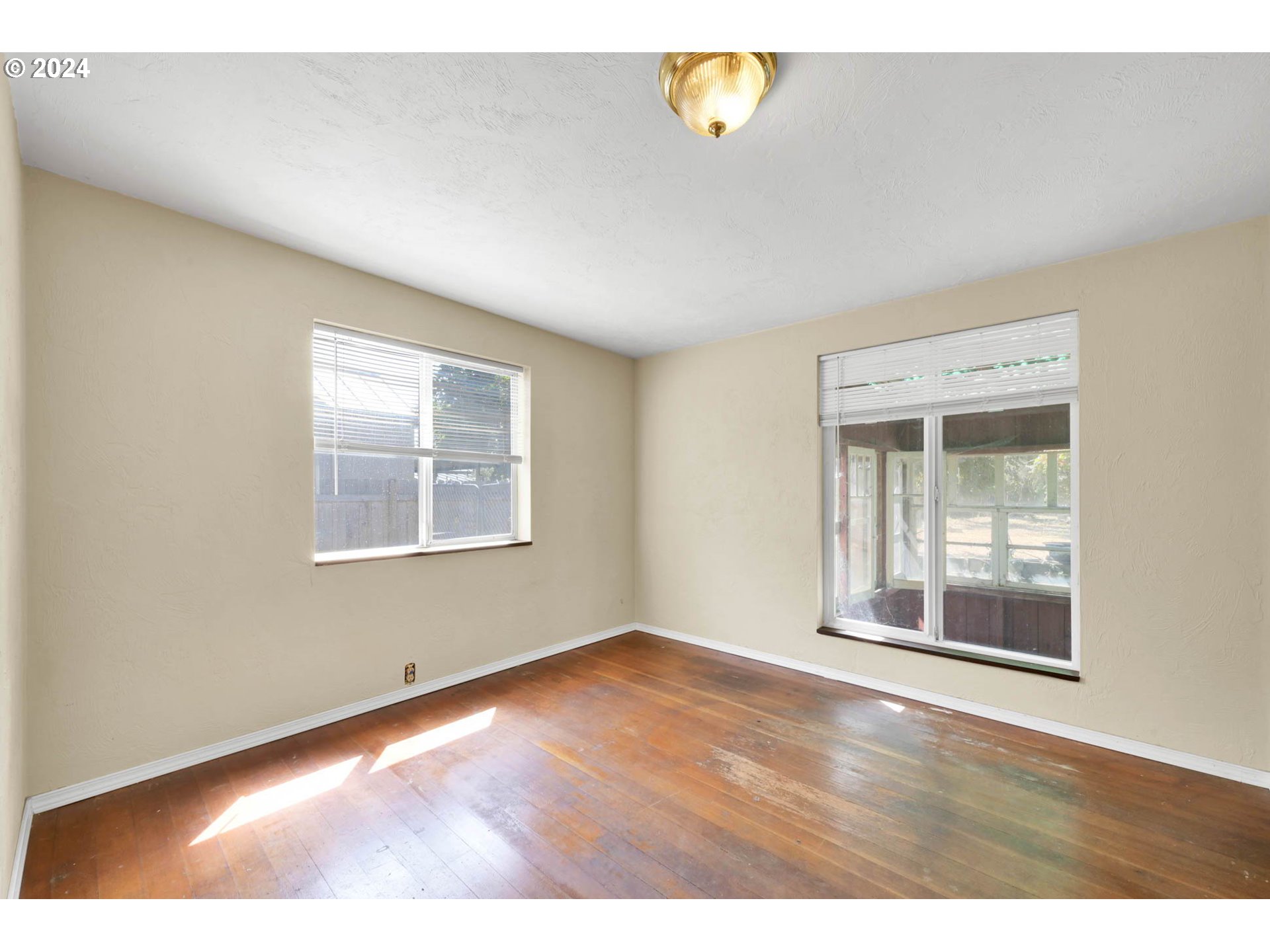 1004 North 3rd Place Springfield, OR 97477 - Photo 11 of 33 an empty room with wooden floor and windows