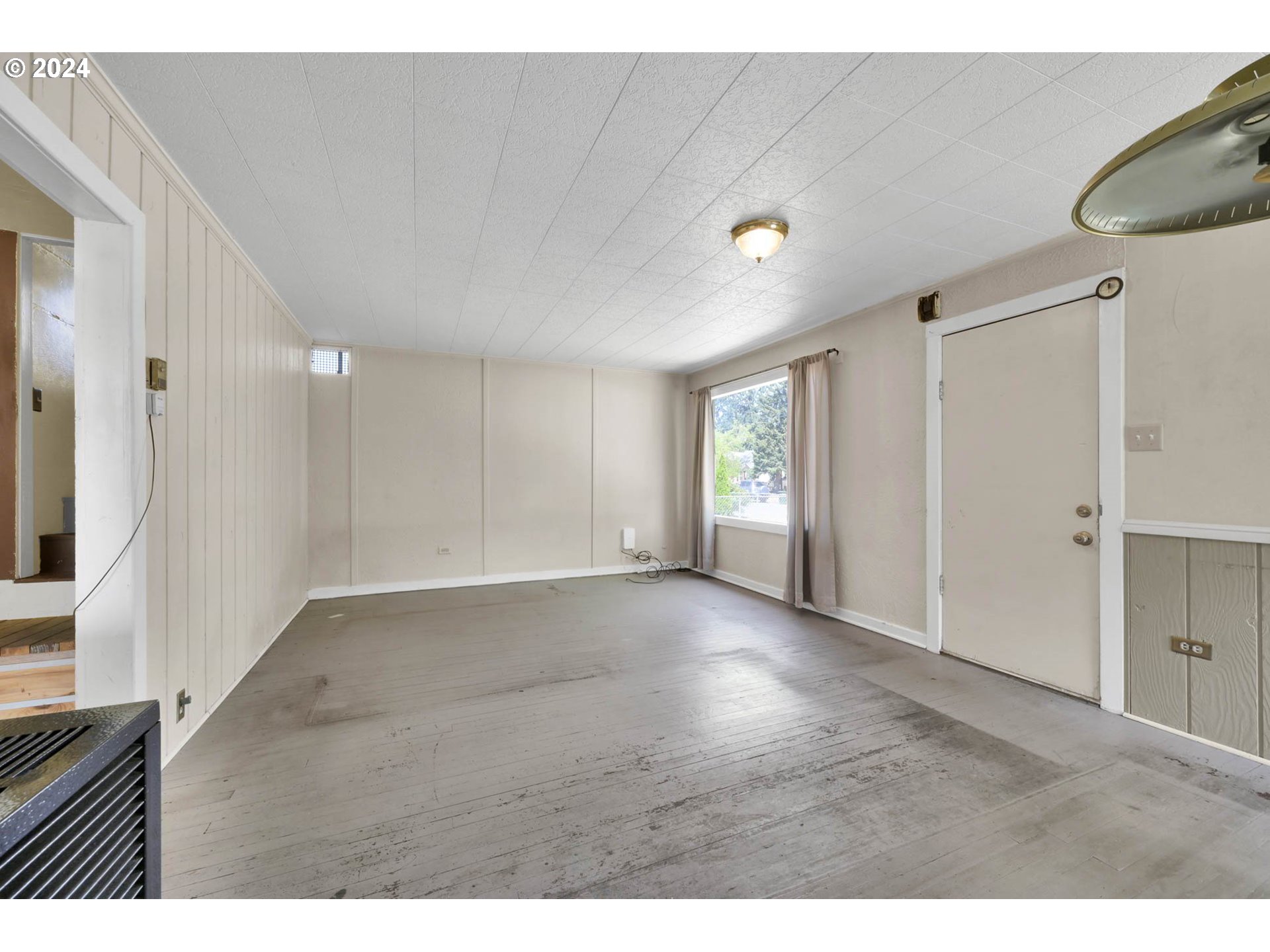 1004 North 3rd Place Springfield, OR 97477 - Photo 3 of 33 a view of an empty room with wooden floor and a window