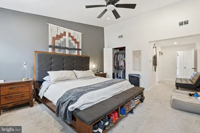 a spacious bedroom with a bed and a chandelier