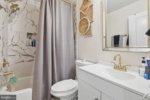 a bathroom with a sink a toilet and shower curtain