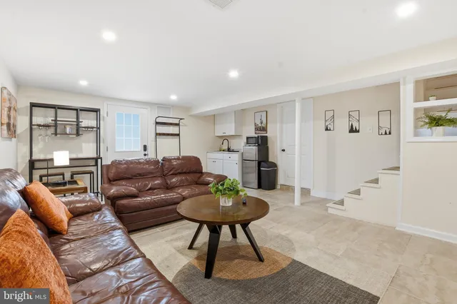 a living room with furniture a lamp a window and a flat screen tv