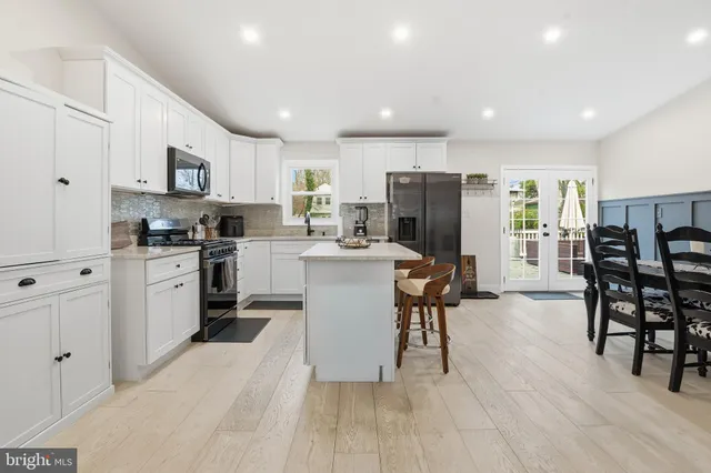 a kitchen with stainless steel appliances a microwave a stove a sink a refrigerator and cabinets